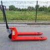 Niskoprofilni ručni paletar Staxx WH-25L-51-H sa produženim vilama, bočni prikaz na otvorenom