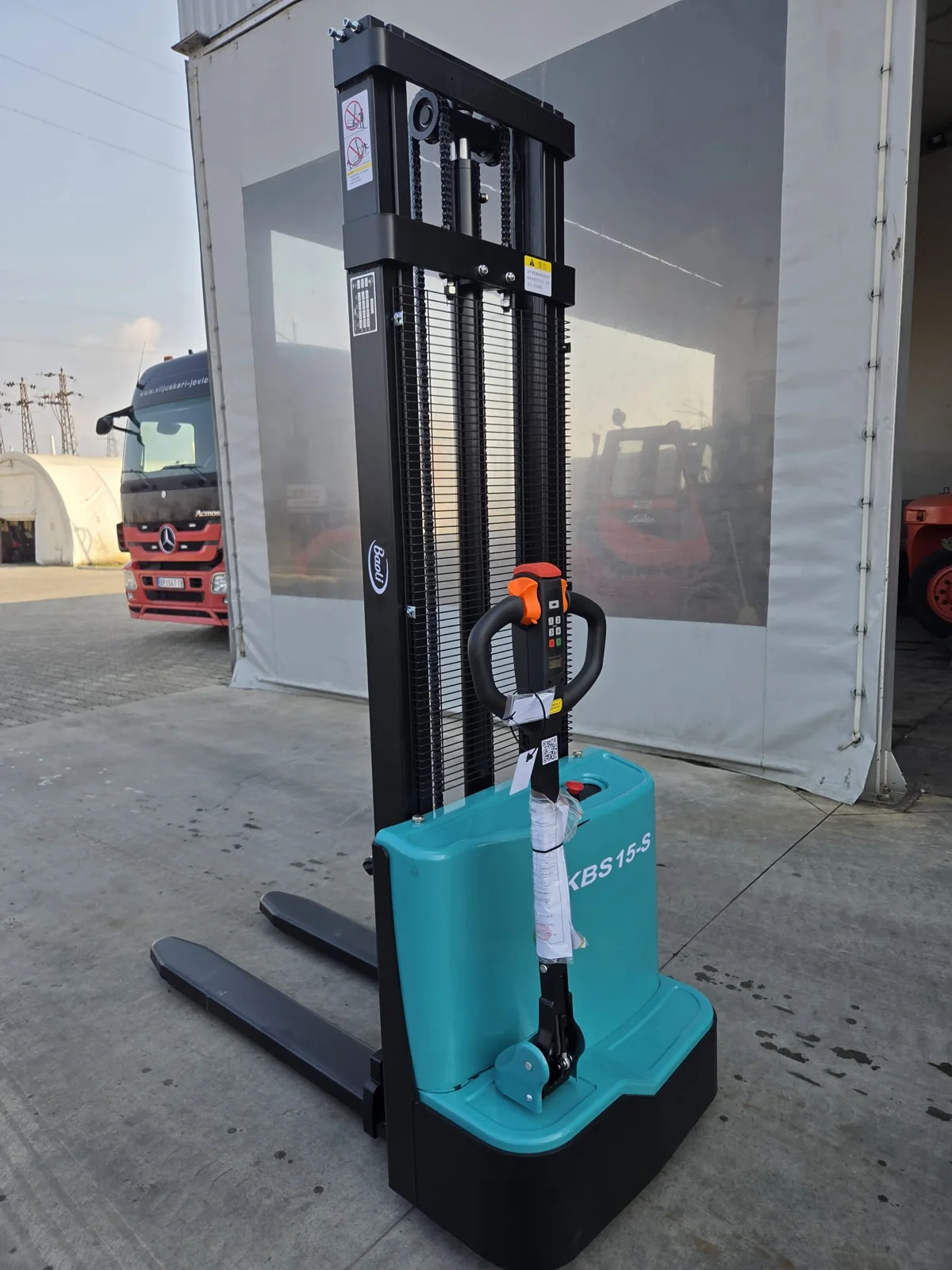 Baoli KBS15-S elektro staker 1.500 kg | Jović Viljuškari Baoli KBS15-S elektro staker nosivosti 1.500 kg, prikaz iz ugla sa upravljačkom rudom, na placu Jović Viljuškari